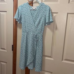Size small light teal dress with small white flowers. Tie detail at the waist.
